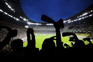 Football, soccer fans support their team and celebrate goal, score, victory. Full stadium